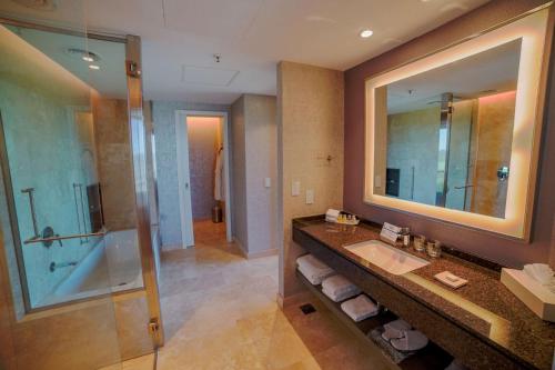 皮拉尔Hilton Pilar的一间带水槽和玻璃淋浴的浴室