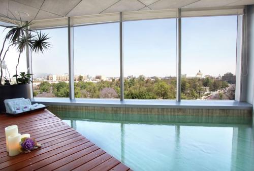 墨西哥城墨西哥城希尔顿改革大道酒店的一座带窗户的建筑中的游泳池