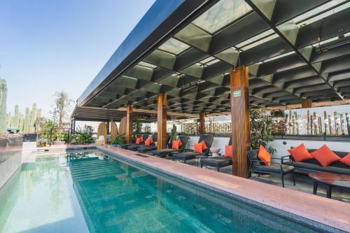 墨西哥城Umbral, Curio Collection By Hilton的一个带椅子和庭院的酒店游泳池