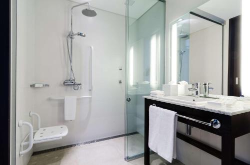 蒙得维的亚汉普顿希尔顿蒙得维亚卡拉斯科酒店的一间带玻璃淋浴和水槽的浴室