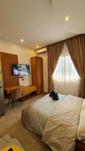 AbagaKBK Lodge的酒店客房配有一张床、一张书桌和一台电视。