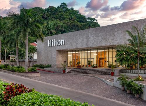 巴亚尔塔港Hilton Vallarta Riviera All-Inclusive Resort,Puerto Vallarta的一座棕榈树环绕的希尔顿建筑