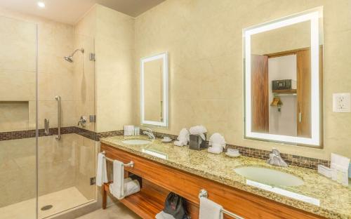 圣何塞德尔卡沃希尔顿洛斯卡沃斯汉普顿酒店的一间带两个盥洗盆和淋浴的浴室