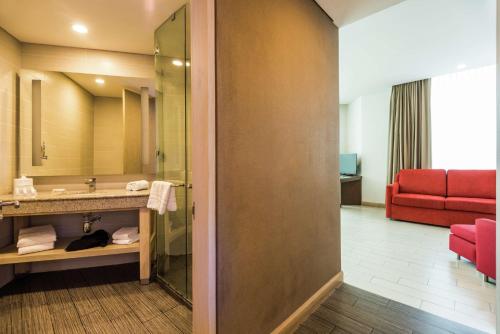 巴兰基亚巴兰基亚希尔顿花园酒店的一间带水槽和红色沙发的酒店浴室