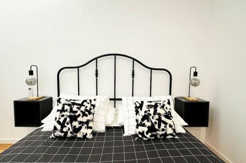 里斯本Stay Well Home的卧室配有带枕头的黑白床。