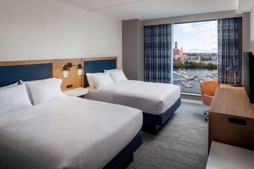 波士顿Hampton Inn Boston Seaport District的酒店客房设有两张床和窗户。