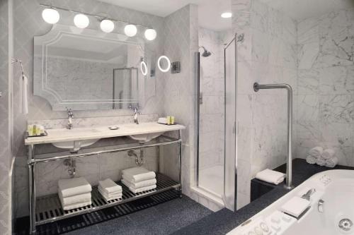 芝加哥The Drake Hotel的浴室配有水槽、淋浴和浴缸。