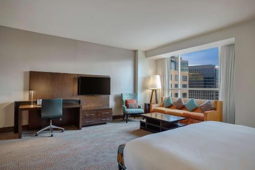 普莱诺达拉斯/普莱诺花岗岩公园希尔顿酒店的酒店客房配有一张床、一张书桌和一台电视。
