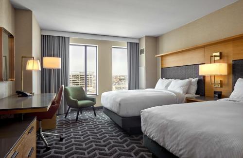 德梅因Hilton Des Moines Downtown的酒店客房配有两张床和一张书桌