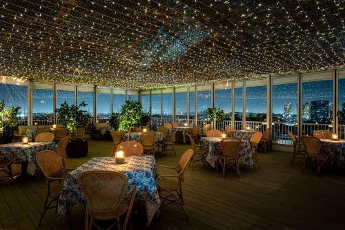 洛杉矶比佛利希尔顿酒店的一间带桌椅和灯光的餐厅