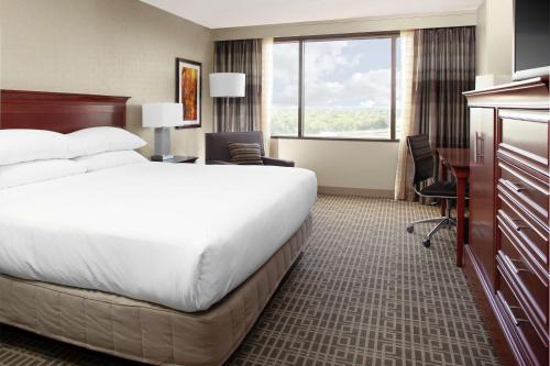 欧弗兰帕克DoubleTree by Hilton Kansas City - Overland Park的酒店客房设有一张大床和一张书桌。
