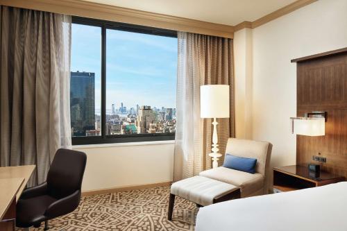 纽约Hilton New York Times Square的酒店的客房 - 带一张床、椅子和窗户