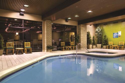 杜兰戈杜兰戈希尔顿逸林酒店的一座配有桌椅的酒店游泳池