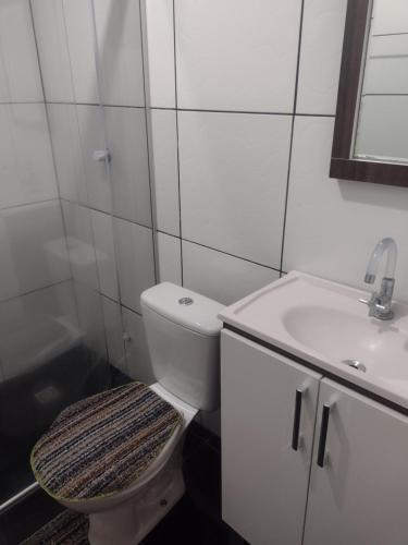格拉玛多Gramado Família的白色的浴室设有卫生间和水槽。