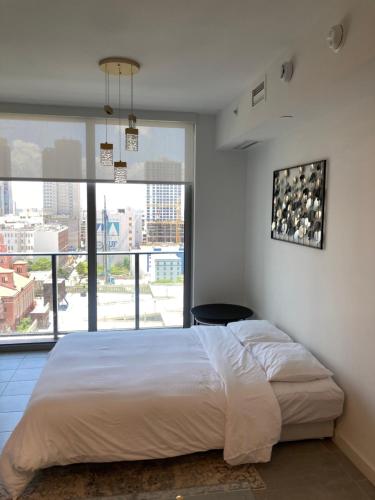 迈阿密Brand NEW modern 1 bedroom unit Downtown的一间卧室设有一张大床和一个大窗户