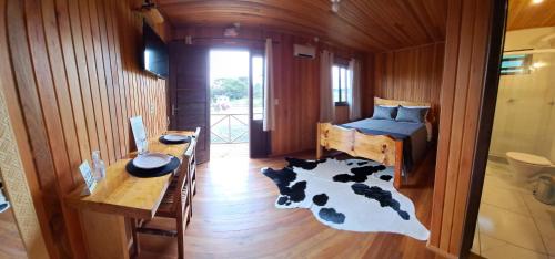 乌鲁比西Chalés Sossego da Serra的卧室配有床和牛地毯
