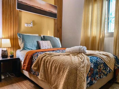 雅温得Roswell Luxury Properties Yaoundé - Quartier FOUDA的一间卧室设有一张大床和一个窗户。