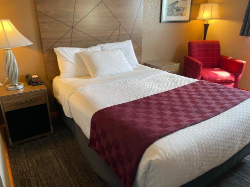林伍德林伍德美国最佳价值酒店的酒店客房,配有一张床和一张红色椅子