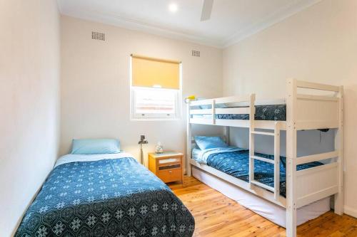 悉尼Beach House Close to Manly的一间卧室设有两张双层床和一扇窗户。