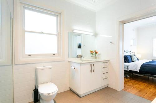 悉尼Beach House Close to Manly的白色的浴室设有卫生间和一张床