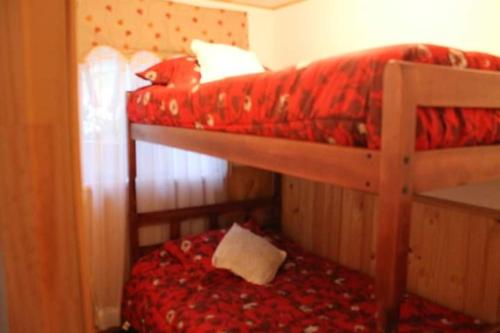 圣地亚哥Cabaña Emilia的一间卧室配有两张双层床和红色毯子