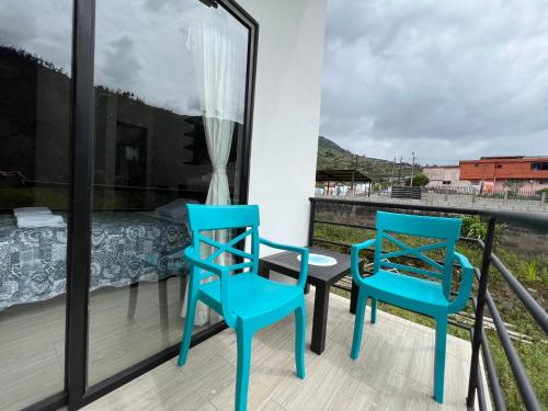 巴尼奥斯Brand new Holiday Villa - 3 bedroom 4 bathroom的阳台配有2把蓝色椅子和1张床