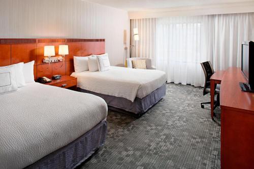 达拉姆杜克大学达勒姆市中心万怡酒店的酒店客房配有两张床和一张书桌