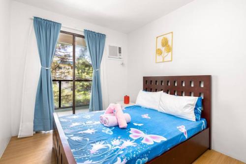 大雅台PineSuites Relaxing 2-bedroom condo with pool and garden view的卧室里设有一张床,上面有一只动物