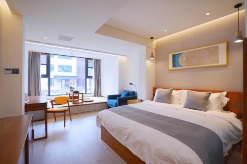 青岛青岛九水和园艺术设计酒店的一间卧室配有一张床、一张桌子和一把椅子