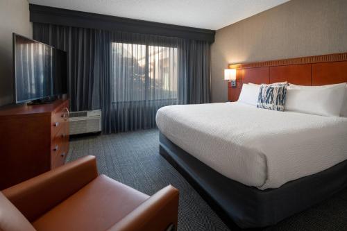贝克斯菲尔德贝克斯菲尔德万怡酒店的酒店客房设有一张大床和一张沙发。