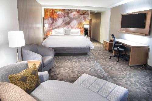 莱诺克斯Courtyard by Marriott Lenox Berkshires的酒店客房设有一张大床和一张书桌。