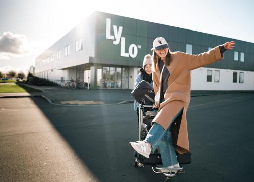 基督城LyLo Christchurch的一名在建筑物前骑滑板的女人