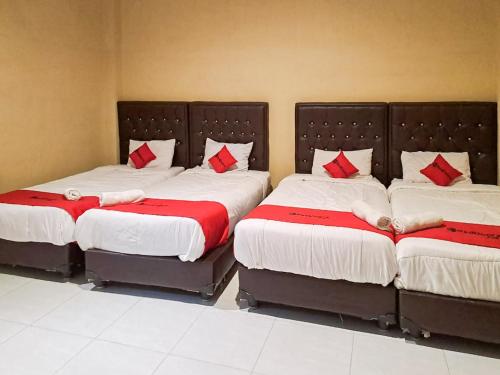 沙璜RedDoorz Syariah At Harley Hotel Sabang的客房内的两张床和红色枕头