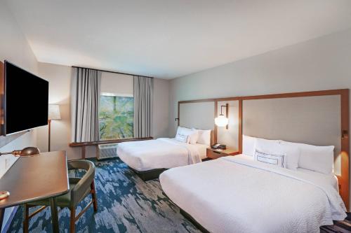 利柏提Fairfield Inn & Suites by Marriott Liberal的酒店客房配有两张床和一张书桌