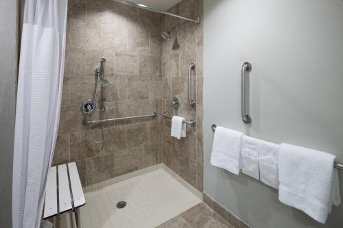 普莱诺达拉斯普莱诺/理查森万怡酒店 的带淋浴和白色毛巾的浴室