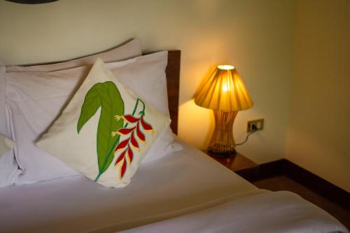 爱妮岛卡德捞度假酒店及餐厅的一张带两个枕头的床和一盏灯