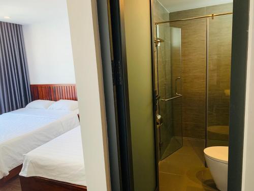 芽庄Luu Gia Hotel的带淋浴、床和卫生间的浴室