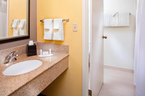 迈阿密迈阿密机场西/多拉尔万怡酒店的浴室配有盥洗盆、镜子和毛巾