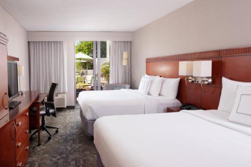 迈阿密迈阿密珊瑚阁万怡酒店的酒店客房配有两张床和一张书桌