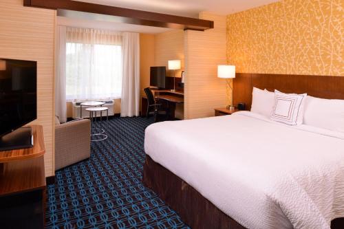 普利茅斯Fairfield Inn & Suites by Marriott Plymouth White Mountains的配有一张床和一台平面电视的酒店客房