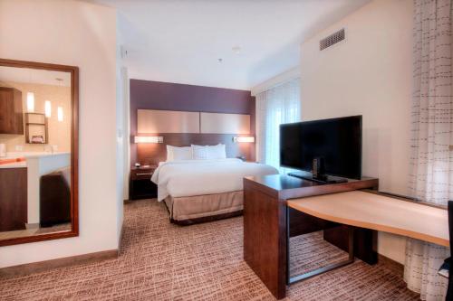 夏洛特Residence Inn by Marriott Charlotte Airport的配有一张床和一台平面电视的酒店客房