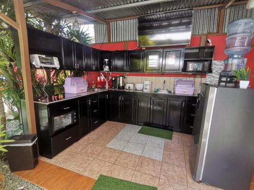 别霍港Roca Mar ROCAWELCH Puerto Viejo的厨房配有黑色橱柜和冰箱。