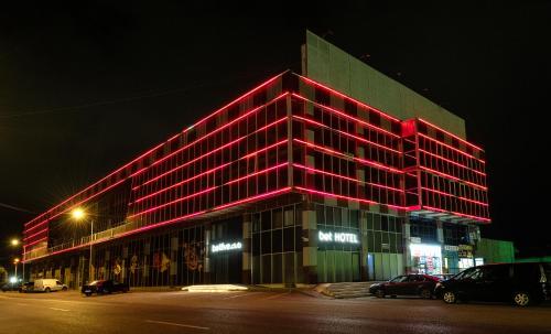 巴统BET25 Hotel的一座大建筑,晚上有红灯