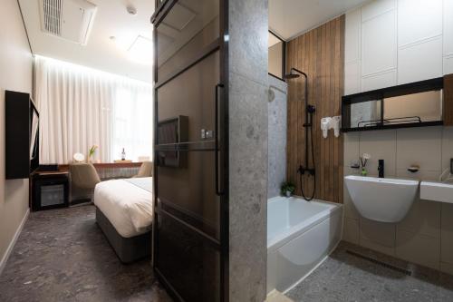 首尔Hotel DM的带浴缸、水槽和床的浴室