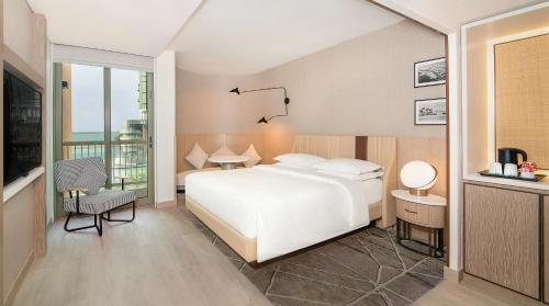 阿布扎比喜来登阿布扎比度假酒店的一间带白色床的卧室和一个阳台
