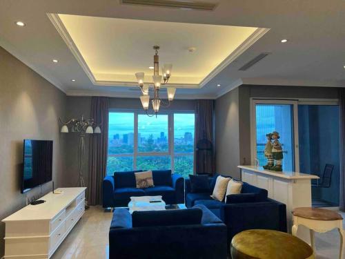 河内Luxury Golf view Apartment Ciputra L2的客厅配有蓝色的沙发和电视