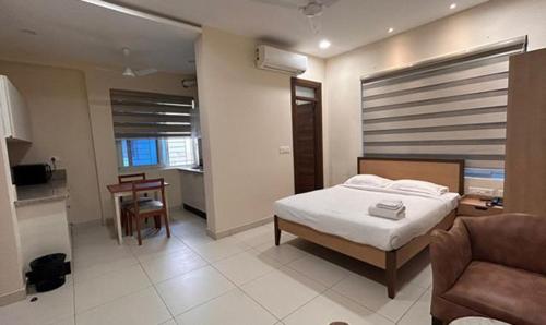海得拉巴FabHotel Prime AM Suites Near Yashoda Hospital的一间卧室配有一张床、一张沙发和一张桌子