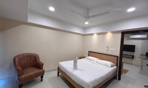 海得拉巴FabHotel Prime AM Suites Near Yashoda Hospital的一间卧室配有一张床和一把椅子