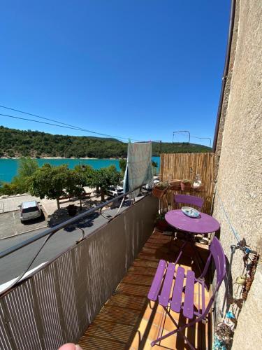 博迪昂balcon sur le lac的阳台配有紫色桌椅和海洋