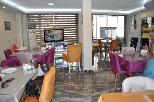 KonakKonak EuroBest Otel的餐厅设有紫色桌椅和电视。
